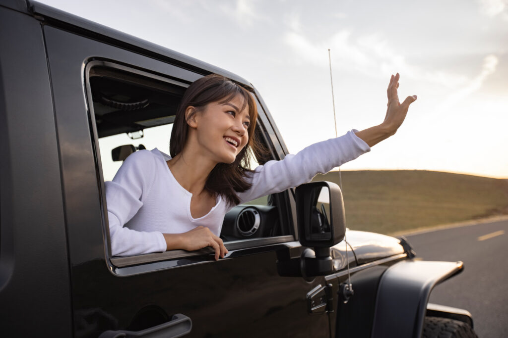 Women waving out of a Jeep Wrangler.